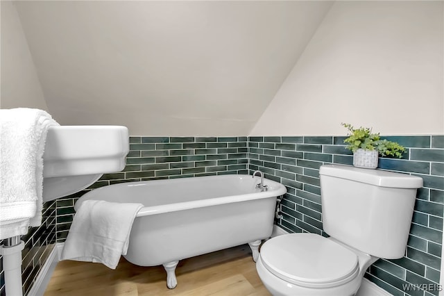 111 Montrose Ave, Buffalo, NY 14214 - bathroom featuring tile walls, a soaking tub, wood finished floors, and a wainscoted wall