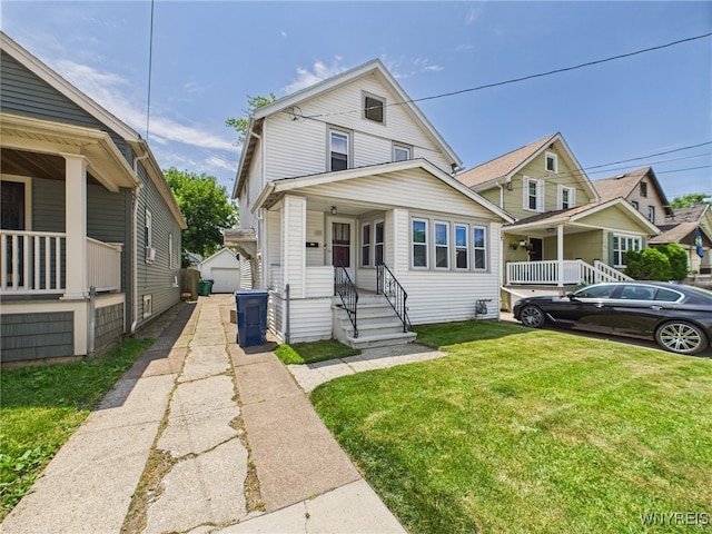 125 Phyllis Ave, Buffalo, NY 14215 - view of front facade featuring covered porch, a front lawn, an outbuilding, and a detached garage