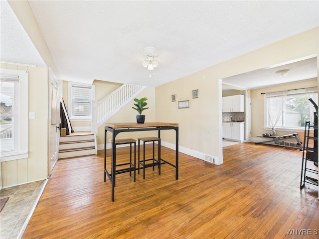 125 Phyllis Ave, Buffalo, NY 14215 - dining area with light wood finished floors, stairway, a textured ceiling, and a ceiling fan