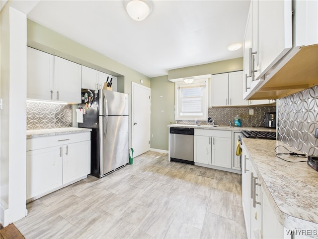 125 Phyllis Ave, Buffalo, NY 14215 - kitchen featuring appliances with stainless steel finishes, light countertops, white cabinets, and tasteful backsplash