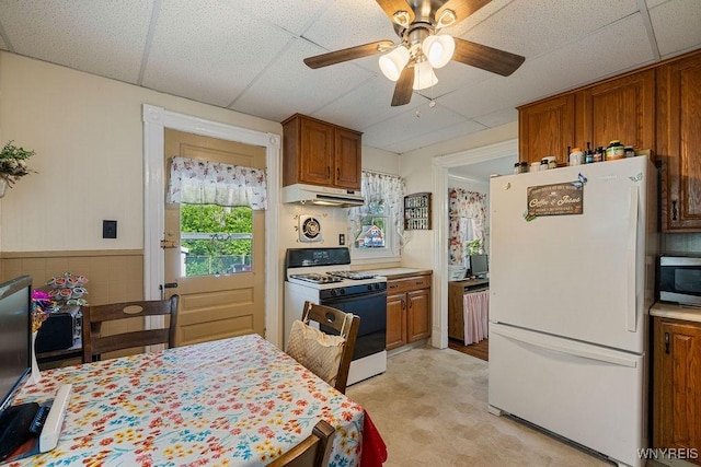 19 Reed St, Lockport City, NY 14094 - kitchen featuring white appliances, under cabinet range hood, light countertops, brown cabinetry, and ceiling fan