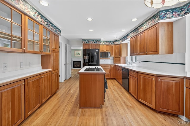 7569 Northfield Ln, Manlius, NY 13104 - kitchen featuring black appliances, a center island, brown cabinetry, light wood finished floors, and recessed lighting