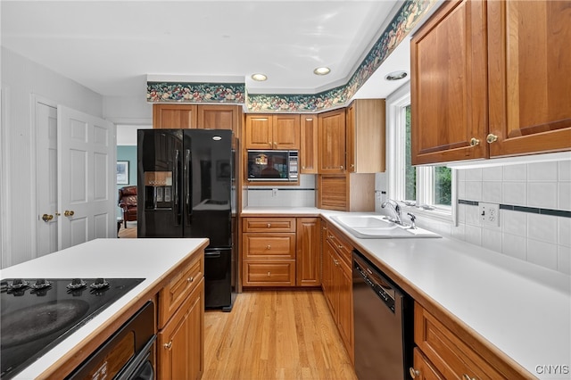 7569 Northfield Ln, Manlius, NY 13104 - kitchen with black appliances, light wood finished floors, brown cabinets, and tasteful backsplash