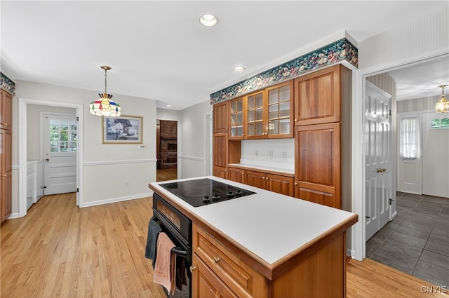 7569 Northfield Ln, Manlius, NY 13104 - kitchen with black appliances, brown cabinetry, glass insert cabinets, light countertops, and recessed lighting