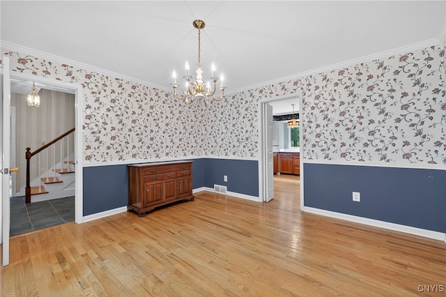 7569 Northfield Ln, Manlius, NY 13104 - empty room featuring a chandelier, wallpapered walls, light wood-style floors, ornamental molding, and stairway