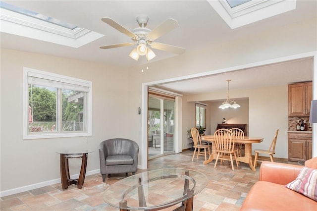 17 Francine Dr, Gates, NY 14606 - living area featuring a skylight, stone tile floors, plenty of natural light, and a ceiling fan