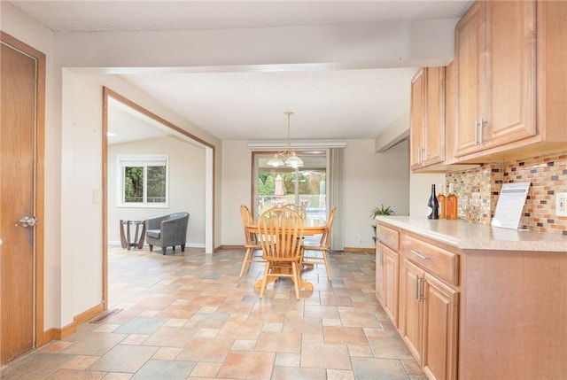 17 Francine Dr, Gates, NY 14606 - dining space featuring plenty of natural light, stone tile floors, and a chandelier