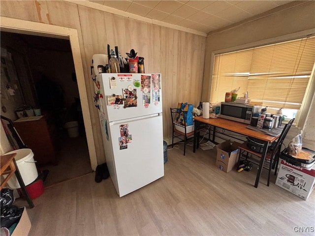 2369 State Route 5, Sullivan, NY 13037 - kitchen featuring freestanding refrigerator, stainless steel microwave, wood finished floors, wooden walls, and a desk