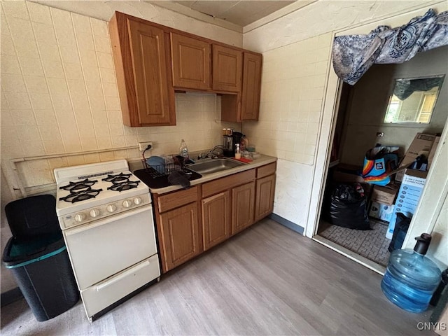 2369 State Route 5, Sullivan, NY 13037 - kitchen featuring white gas stove, light wood finished floors, brown cabinets, and light countertops