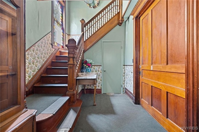 2469 Seneca St, West Seneca, NY 14210 - foyer entrance with carpet, stairway, a chandelier, wainscoting, and a decorative wall
