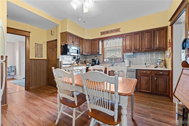 2469 Seneca St, West Seneca, NY 14210 - kitchen featuring stainless steel microwave, white gas range oven, a wainscoted wall, wood finished floors, and ceiling fan