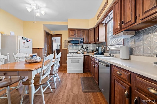 2469 Seneca St, West Seneca, NY 14210 - kitchen featuring stainless steel appliances, a ceiling fan, light wood-type flooring, a wainscoted wall, and light countertops