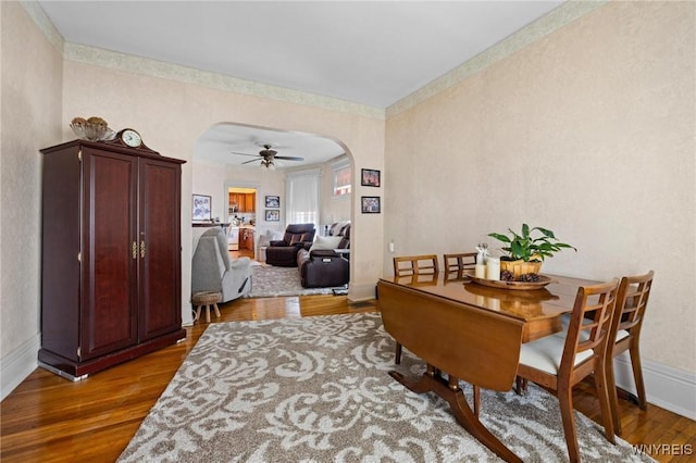 2469 Seneca St, West Seneca, NY 14210 - dining room featuring arched walkways, wood finished floors, and a ceiling fan