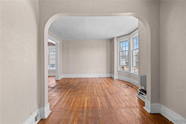 2469 Seneca St, West Seneca, NY 14210 - empty room featuring arched walkways and hardwood / wood-style flooring