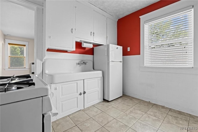 2469 Seneca St, West Seneca, NY 14210 - kitchen featuring white appliances, light tile patterned flooring, and white cabinets