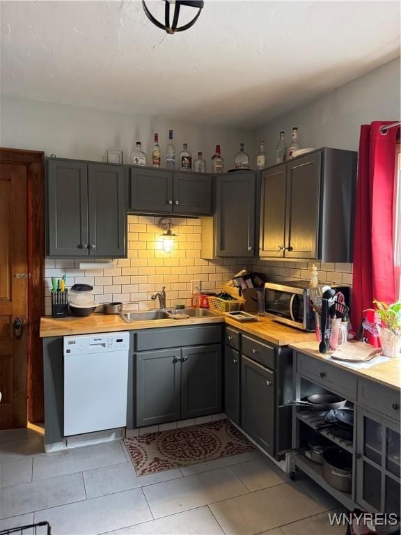 51 Ashton Pl, Buffalo, NY 14220 - kitchen featuring white dishwasher, stainless steel microwave, backsplash, and light tile patterned flooring