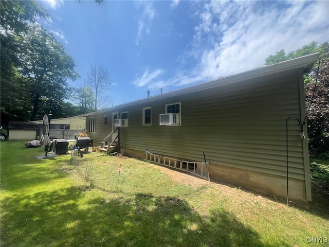 20 Pond Path, Oswego, NY 13126 - rear view of house with entry steps, a yard, an AC wall unit, and an outbuilding