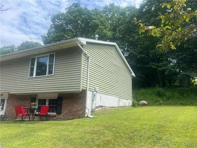 20 Pond Path, Oswego, NY 13126 - view of home's exterior featuring a yard, brick siding, and a patio