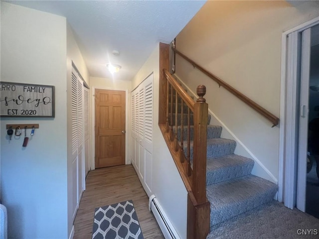 20 Pond Path, Oswego, NY 13126 - staircase featuring a baseboard radiator and wood finished floors