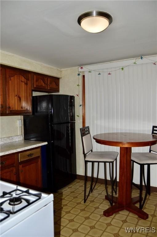 77 Harlem Rd, West Seneca, NY 14224 - kitchen featuring white range oven, freestanding refrigerator, light countertops, and light flooring