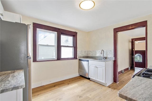 153 Hinman Ave, Buffalo, NY 14216 - kitchen with stainless steel appliances, light wood-style floors, white cabinets, backsplash, and light countertops