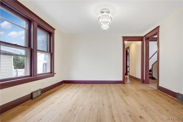 153 Hinman Ave, Buffalo, NY 14216 - empty room with plenty of natural light, light wood finished floors, and a chandelier