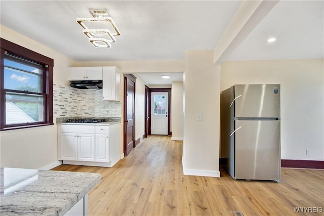 153 Hinman Ave, Buffalo, NY 14216 - kitchen featuring stainless steel appliances, extractor fan, white cabinets, light wood-style flooring, and backsplash