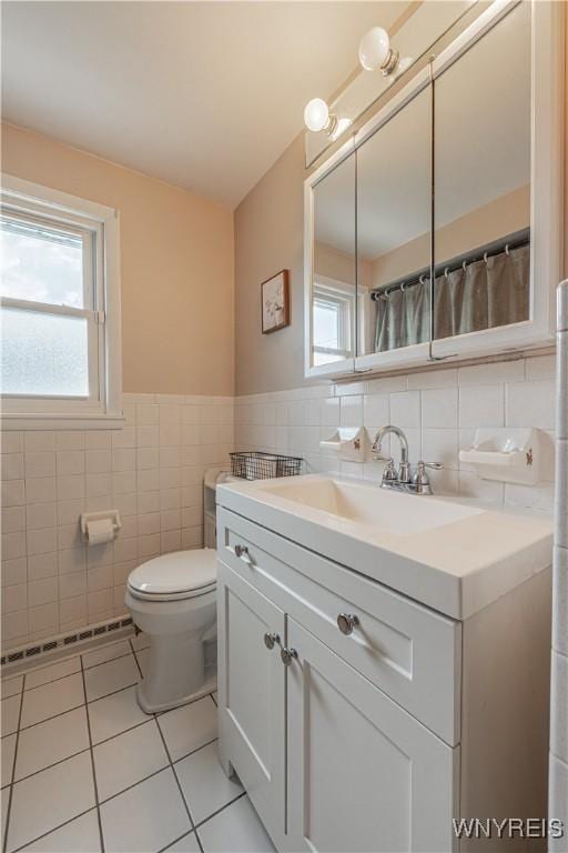 24 Ceil Dr, Cheektowaga, NY 14227 - full bathroom featuring tile walls, tile patterned flooring, vanity, a baseboard heating unit, and a wainscoted wall
