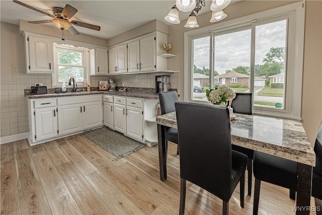 24 Ceil Dr, Cheektowaga, NY 14227 - kitchen featuring open shelves, light wood finished floors, white cabinetry, backsplash, and ceiling fan