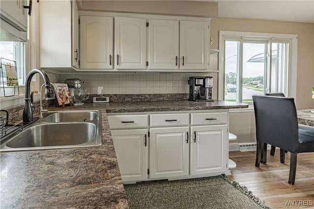 24 Ceil Dr, Cheektowaga, NY 14227 - kitchen with dark countertops, wood finished floors, white cabinets, and backsplash