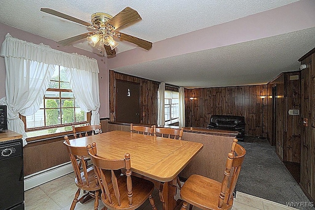 4 Windtree Ln, West Seneca, NY 14224 - dining room featuring a textured ceiling, a baseboard radiator, wood walls, a ceiling fan, and light tile patterned floors