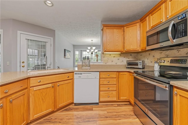 65 Sotheby Dr, Greece, NY 14626 - kitchen with stainless steel appliances, light wood-type flooring, a chandelier, light countertops, and tasteful backsplash