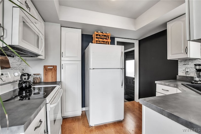 1871 Eggert Rd, Amherst, NY 14226 - kitchen with white appliances, dark countertops, white cabinets, backsplash, and light wood-style flooring