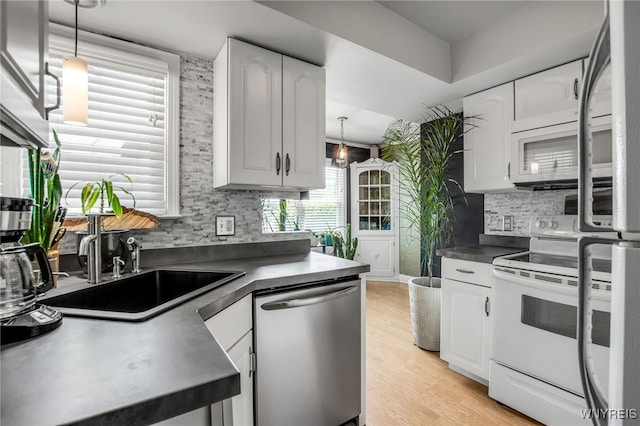 1871 Eggert Rd, Amherst, NY 14226 - kitchen with white appliances, dark countertops, tasteful backsplash, and white cabinetry