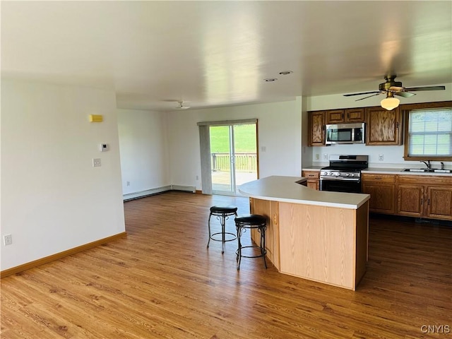 3370 Hicks Rd, Scipio, NY 13118 - kitchen featuring appliances with stainless steel finishes, a baseboard radiator, dark wood-style flooring, and light countertops
