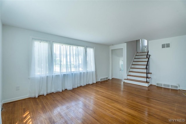 165 Kelvin Dr, Tonawanda, NY 14223 - unfurnished living room with healthy amount of natural light, stairs, and wood finished floors
