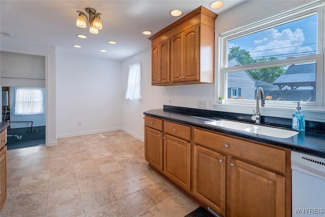 165 Kelvin Dr, Tonawanda, NY 14223 - kitchen with white dishwasher, dark countertops, and brown cabinets