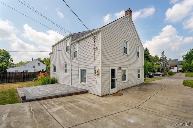 165 Kelvin Dr, Tonawanda, NY 14223 - rear view of house with a patio and a chimney