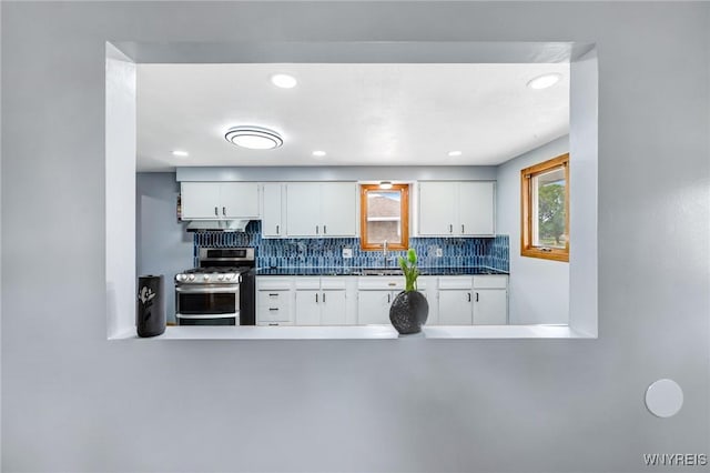 41 Dennis Ln, Cheektowaga, NY 14227 - kitchen with range with two ovens, tasteful backsplash, white cabinets, dark countertops, and under cabinet range hood