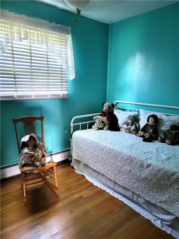138 Dingman Hill Rd, Bainbridge, NY 13733 - bedroom featuring wood finished floors and a baseboard heating unit