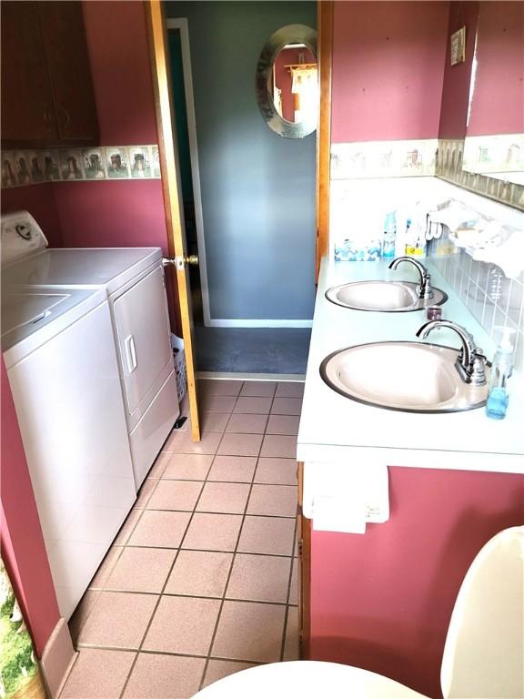 138 Dingman Hill Rd, Bainbridge, NY 13733 - half bathroom with independent washer and dryer, double vanity, and tile patterned floors