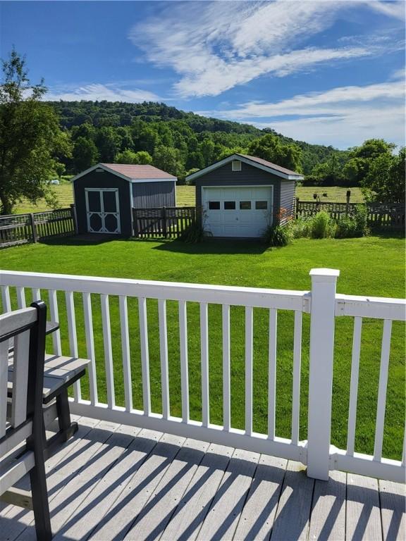 138 Dingman Hill Rd, Bainbridge, NY 13733 - wooden terrace featuring an outdoor structure, a detached garage, and a forest view