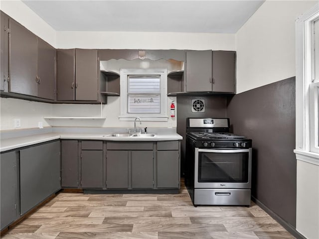 896-898 S Plymouth Ave, Rochester, NY 14608 - kitchen featuring stainless steel range with gas cooktop, open shelves, light wood finished floors, light countertops, and gray cabinetry