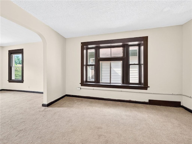 896-898 S Plymouth Ave, Rochester, NY 14608 - carpeted empty room featuring a textured ceiling and arched walkways