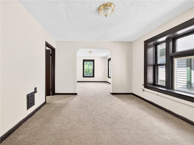 896-898 S Plymouth Ave, Rochester, NY 14608 - carpeted empty room featuring arched walkways and a textured ceiling
