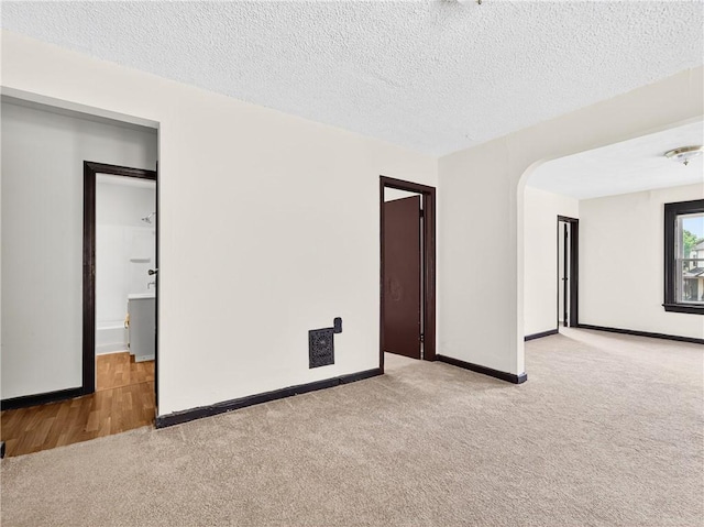 896-898 S Plymouth Ave, Rochester, NY 14608 - empty room featuring carpet, a textured ceiling, and arched walkways