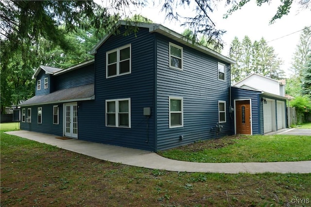 7545 River Rd, Lysander, NY 13027 - back of property featuring a garage, french doors, and driveway