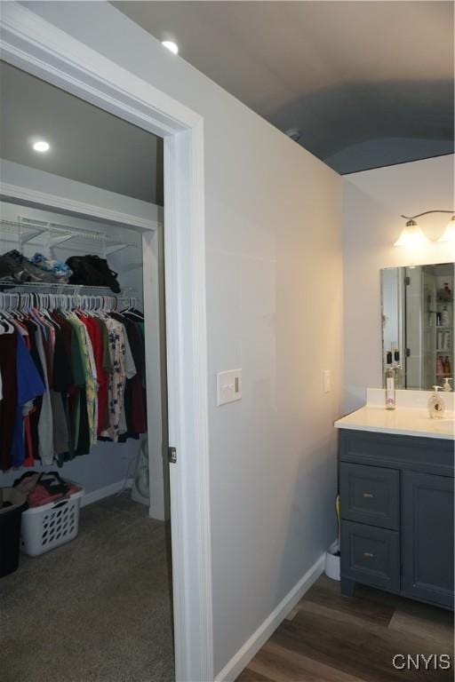 7545 River Rd, Lysander, NY 13027 - bathroom featuring vanity, a spacious closet, and vaulted ceiling