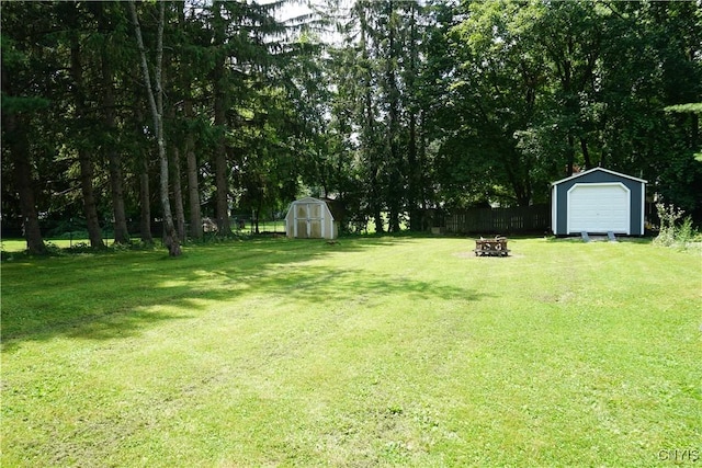 7545 River Rd, Lysander, NY 13027 - fenced backyard with a storage shed, a fire pit, and a detached garage