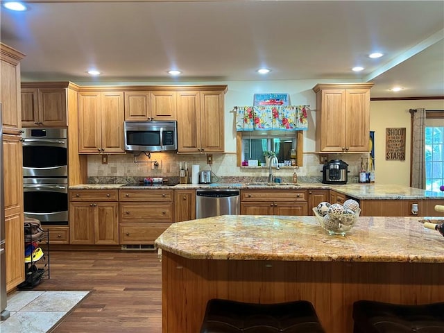 110 Mcmaster St, Bath, NY 14810 - kitchen with stainless steel appliances, a breakfast bar, dark wood finished floors, decorative backsplash, and recessed lighting
